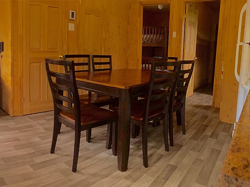Vue de la salle à manger d'un chalet avec portes qui donnent sur les chambres